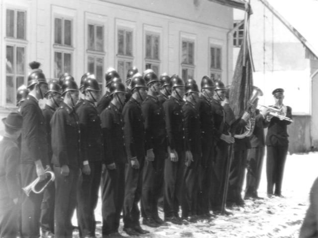 Gruppe von Dorfmännern vor einem Gebäude